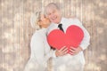 Composite image of older affectionate couple holding red heart shape Royalty Free Stock Photo