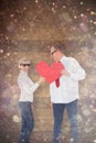 Composite image of older affectionate couple holding red heart shape Royalty Free Stock Photo