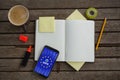 Composite image of organizer, coffee, mobile phone and stationery on wooden plank