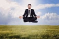 Composite image of peaceful businessman sitting in lotus pose relaxing