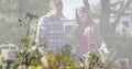 Composite image of plants against caucasian father and daughter gardening together in the garden Royalty Free Stock Photo