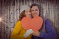 Composite image of portarit of happy couple holding paper heart