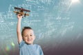 Composite image of portrait of boy holding wooden toy airplane Royalty Free Stock Photo