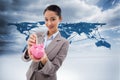 Composite image of portrait of a businesswoman putting a bank note in a piggy bank Royalty Free Stock Photo