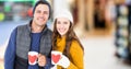 Composite image of portrait of caucasian couple holding mugs smiling against supermarket Royalty Free Stock Photo