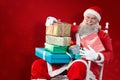 Composite image of portrait of cheerful santa claus holding christmas presents on chair Royalty Free Stock Photo