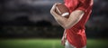 Composite image of portrait of confident american football player in red jersey holding ball Royalty Free Stock Photo