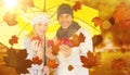 Composite image of portrait of couple holding autumn leaves while standing under yellow umbrella Royalty Free Stock Photo