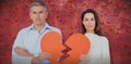 Composite image of portrait of couple holding broken heart shape paper Royalty Free Stock Photo