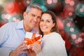 Composite image of portrait of couple holding gift Royalty Free Stock Photo