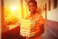 Composite image of portrait of cute boy carrying books in library Royalty Free Stock Photo