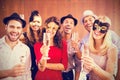 Composite image of portrait of friends holding champagne flute while standing together