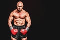 Composite image of portrait full length of bald boxer flexing muscles