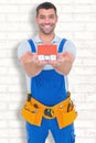 Composite image of portrait of happy construction worker holding house model Royalty Free Stock Photo