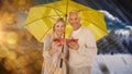 Composite image of portrait of happy couple under yellow umbrella Royalty Free Stock Photo