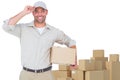 Composite image of portrait of happy delivery man with cardboard box wearing cap Royalty Free Stock Photo