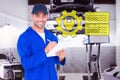 Composite image of portrait of happy male mechanic writing on clipboard Royalty Free Stock Photo