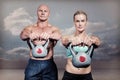 Composite image of portrait of muscular man and woman lifting kettlebells Royalty Free Stock Photo