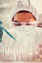 Composite image of portrait of a protected female science student dropping blue liquid in a test tub