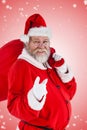 Composite image of portrait of santa claus pointing while carrying christmas bag Royalty Free Stock Photo
