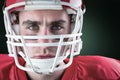 Composite image of portrait of a serious american football player taking his helmet looking at camer Royalty Free Stock Photo