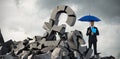 Composite image of portrait of serious businessman holding blue umbrella and file