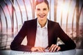 Composite image of portrait of smiling businesswoman typing on keyboard at desk Royalty Free Stock Photo