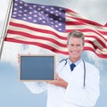 Composite image of portrait of smiling male doctor holding blank slate Royalty Free Stock Photo