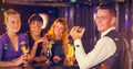 Composite image of portrait of waiter and beautiful women standing at bar counter