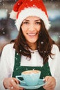 Composite image of portrait of woman with santa hat holding coffee Royalty Free Stock Photo