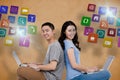 Composite image of portrait of young happy couple using laptop while sitting Royalty Free Stock Photo