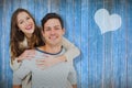 Composite image of portrait of young man giving piggy back to girlfriend Royalty Free Stock Photo