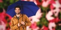 Composite image of portrait of young man holding blue umbrella Royalty Free Stock Photo