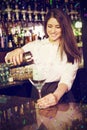 Composite image of pretty bartender pouring blue martini drink in glass Royalty Free Stock Photo