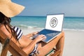 Composite image of pretty brunette using laptop on deck chair Royalty Free Stock Photo