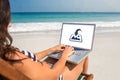 Composite image of pretty brunette using laptop on deck chair Royalty Free Stock Photo