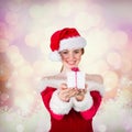 Composite image of pretty girl in santa costume holding gift box Royalty Free Stock Photo