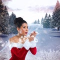 Composite image of pretty santa girl blowing over her hands Royalty Free Stock Photo