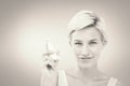 Composite image of pretty woman holding inhaler smiling at camera Royalty Free Stock Photo