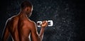 Composite image of rear view of a fit shirtless young man lifting dumbbell Royalty Free Stock Photo