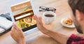 Composite image of rear view of man using tablet on wooden table Royalty Free Stock Photo