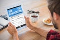 Composite image of rear view of man using tablet on wooden table Royalty Free Stock Photo