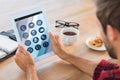 Composite image of rear view of man using tablet on wooden table Royalty Free Stock Photo