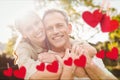 Composite image of red hanging heart and couple embracing each other Royalty Free Stock Photo