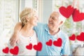 Composite image of red hanging hearts and senior couple embracing Royalty Free Stock Photo