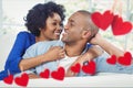 Composite image of red hanging hearts and smiling couple embracing Royalty Free Stock Photo