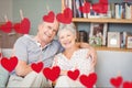 Composite image of red heart and senior couple embracing on sofa Royalty Free Stock Photo