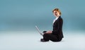 Composite image of redhead businesswoman using her laptop Royalty Free Stock Photo