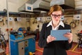 Composite image of redhead businesswoman using her tablet pc Royalty Free Stock Photo