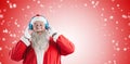 Composite image of santa claus listening music on headphones Royalty Free Stock Photo